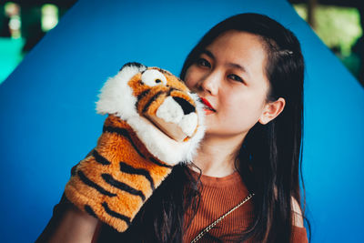 Portrait of young woman with toy animal