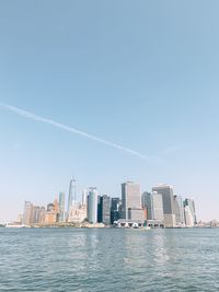 Modern buildings by sea against sky