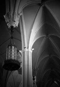 Low angle view of illuminated lamp hanging on ceiling of building
