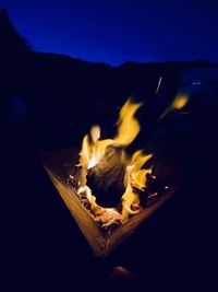 Bonfire on wooden structure against sky at night