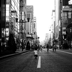 People on road amidst buildings at ginza