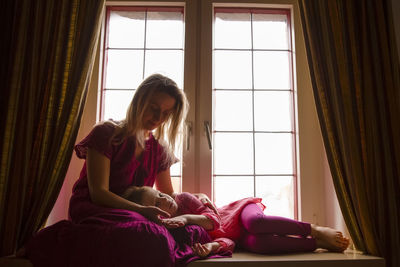 Woman sitting by window at home