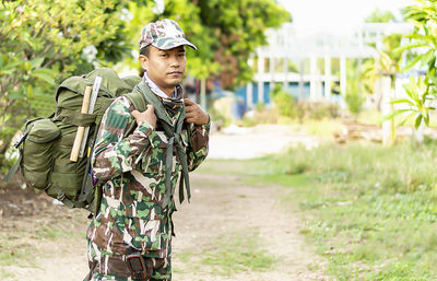 Portrait of soldier standing agaisnt trees