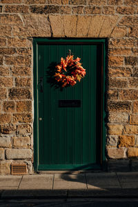 Closed door of old house with wreath