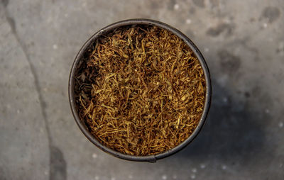 Tobacco in a can on a cement floor