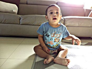 Portrait of boy sitting on sofa at home