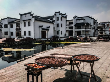 Chairs and table in town against buildings in city