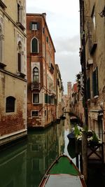 Canal amidst buildings against sky