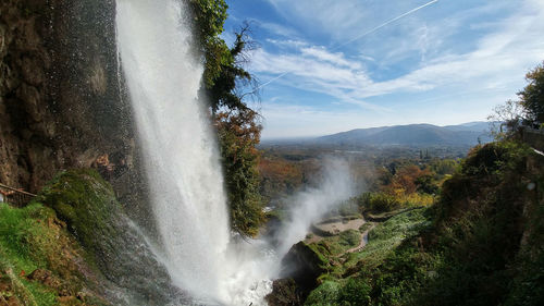 Scenic view of waterfall against sky