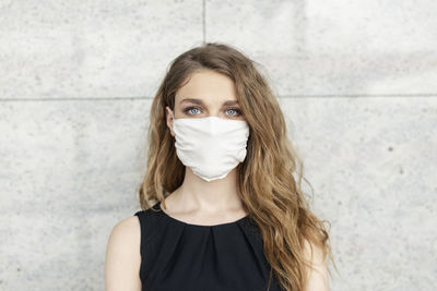 Portrait of a beautiful young woman against wall