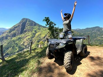 Man riding motorcycle on mountain against sky