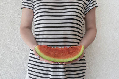 Midsection of woman holding watermelon