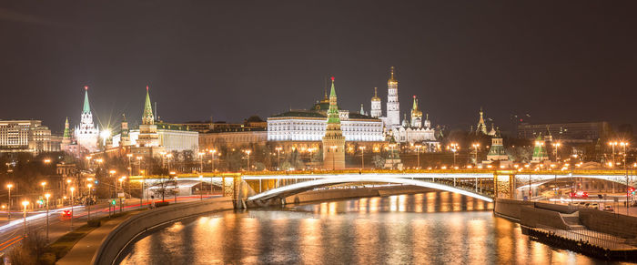 Night wide angle panoramic view of moscow downtown with kremlin, bridges and river reflections