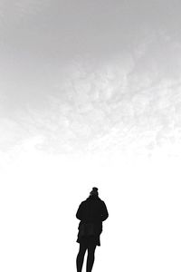 Silhouette man on rock against sky