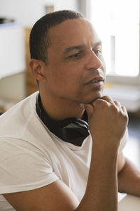 Thoughtful male entrepreneur with hand on chin at office