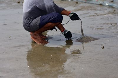 Rear view of man working at beach