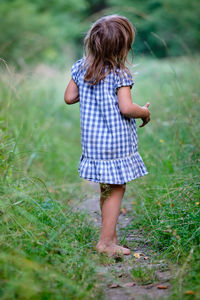 Rear view of girl standing on field