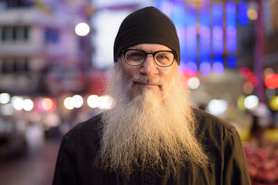 Portrait of man wearing hat standing at night