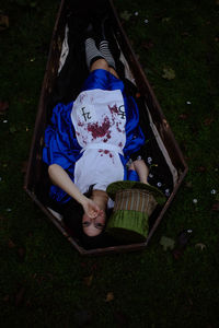 High angle view of woman sitting on grassy field