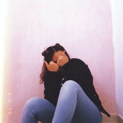 Woman sitting on wall at home