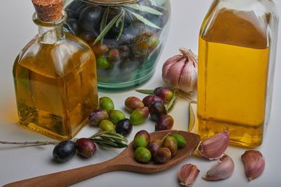 Striking oil bottles surrounded by several ripe olives