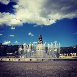 Statue in city against sky