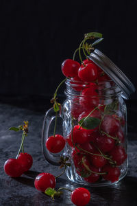 Sweet cherry in a glass on black background. juicy fruits, low key, close-up.