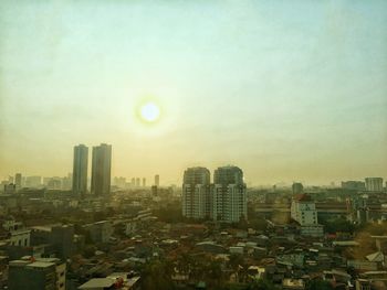 Buildings in city against sky during sunset