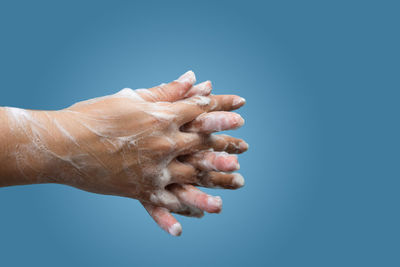 Close-up of hand against blue background