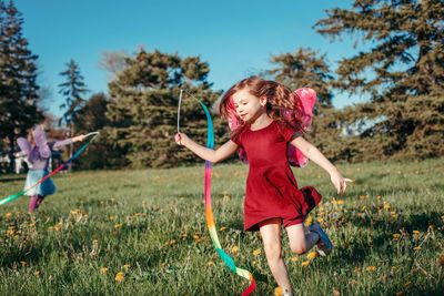 Friends playing with ribbon at park