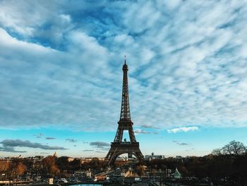 Eiffel tower against cloudy sky