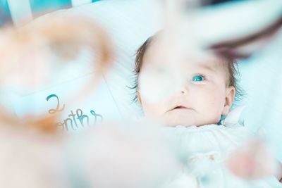 Portrait of cute baby lying on bed