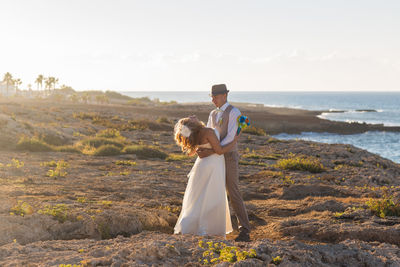 Full length of man standing on beach against sky