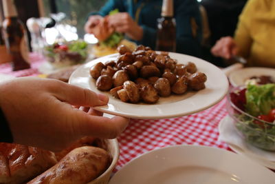 Close-up of hand holding food on table