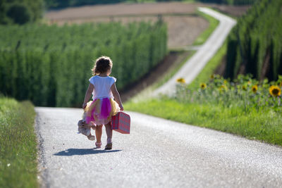 Rear view of woman walking on road