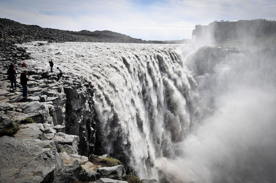 Scenic view of waterfall against sky