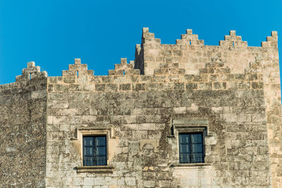 Low angle view of historical building against blue sky