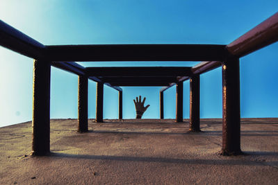 Rear view of man standing against blue sky