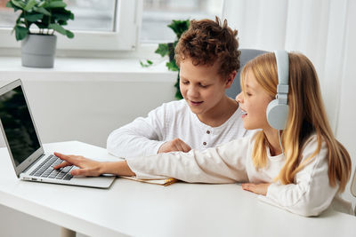 Young woman using laptop at table