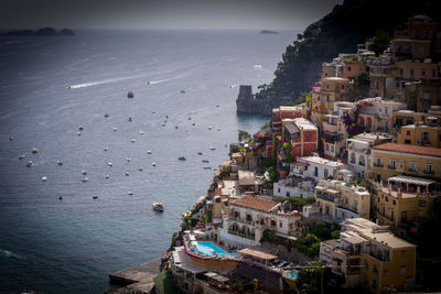 High angle view of townscape by sea against sky
