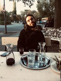 Portrait of young man sitting at restaurant table