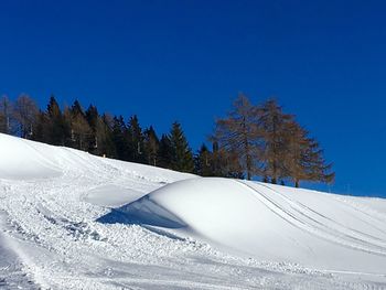 Scenic view of snow covered mountains against clear blue sky