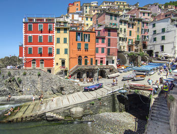 Ligurian town of manarola with tourists and moored boats