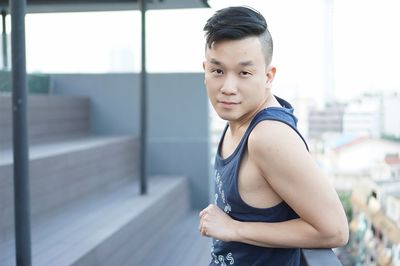 Side view portrait of man wearing tank top by railing