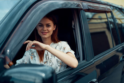 Portrait of a smiling young woman in car