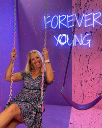 Portrait of a smiling young woman against graffiti wall
