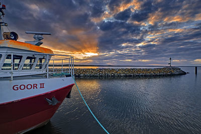 Ship moored at sea against sky during sunset