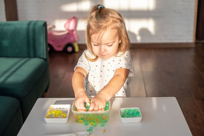 High angle view of cute girl playing with marbles