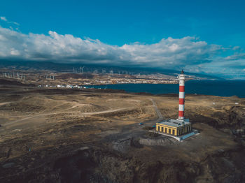 Lighthouse by sea against sky