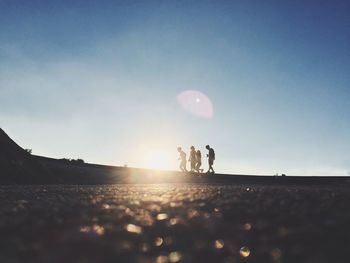 People walking on road at sunset